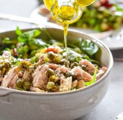 Tuna salad with mixed greens, olives, and a drizzle of olive oil